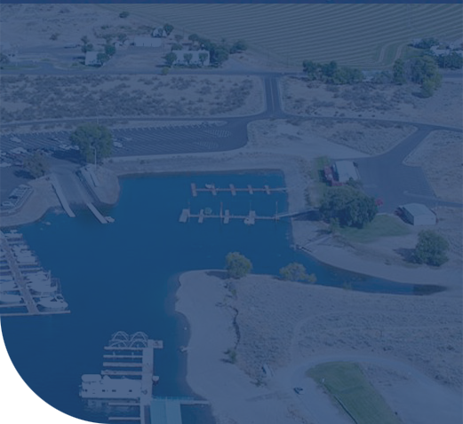 Aerial view of a marina with docks, shoreline, and parking area.