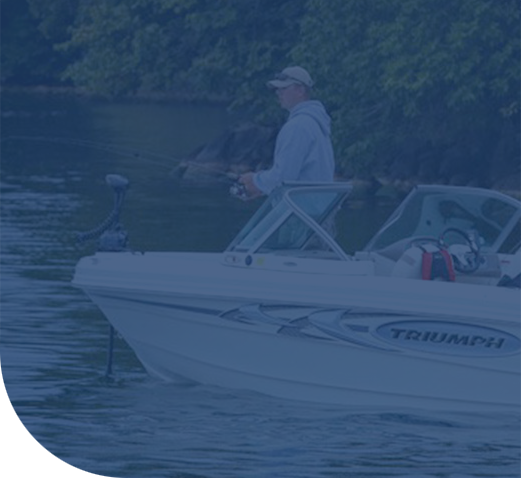 Man fishing from a small motorboat on a calm lake.