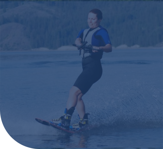 Wakeboarder gliding across the lake while holding a tow handle.