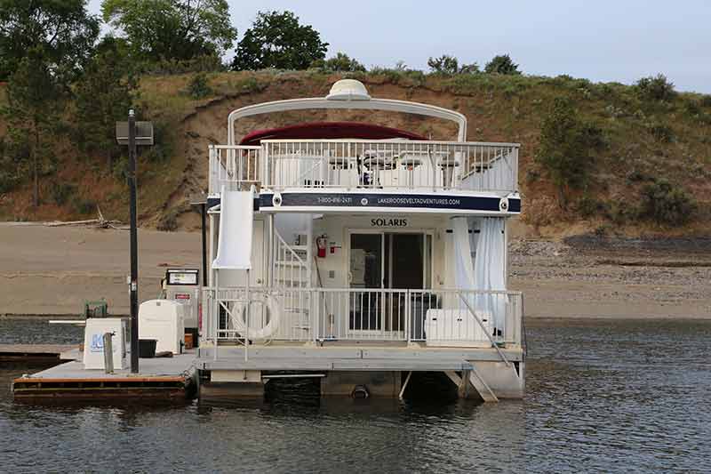 A houseboat named Solaris docked at a fuel station on the lake.