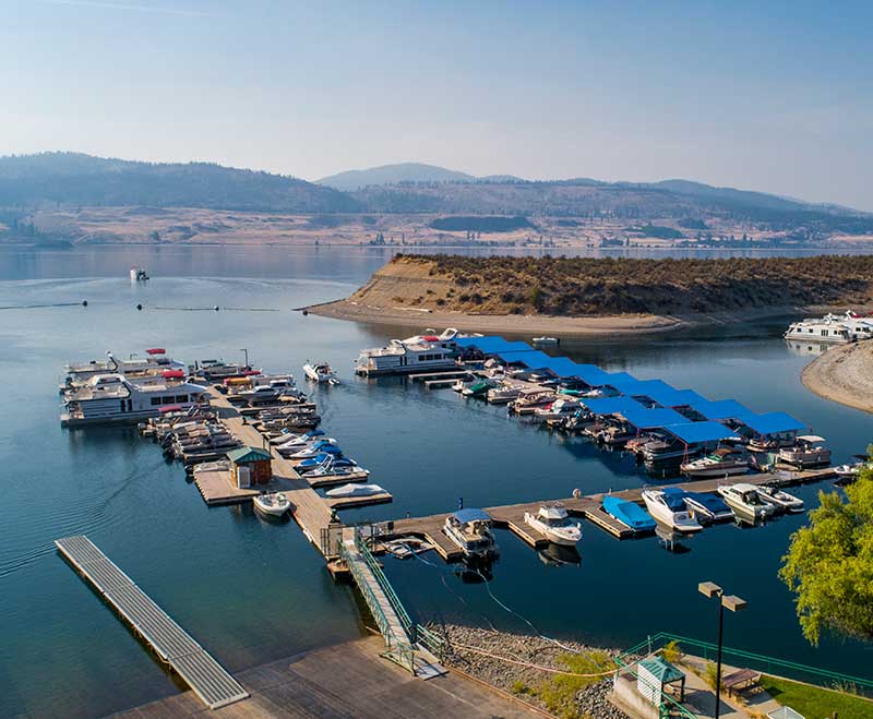 Aerial view of marina docks with boats and covered slips on the lake.
